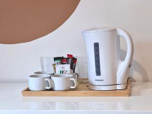 a coffee maker and cups on a wooden shelf at Roost Hill Guest House - Free Parking in Edinburgh