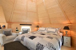 um quarto com uma cama e um tecto de madeira em Seal Point Cabin - Luxury Glamping em Cairndow