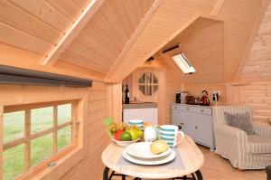 a table with a bowl of fruit on it in a cabin at Seal Point Cabin - Luxury Glamping in Cairndow