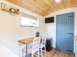 a kitchen with a table and chairs and a blue door at Rose in Redruth