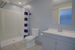 a bathroom with a toilet and a sink and a shower at Dhimas Bayview Suites in Ocean City