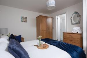 a bedroom with a white bed with blue pillows at Kerensa in Portreath