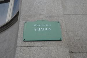 a green street sign sitting on the side of a building at Hotel Paulista in Porto