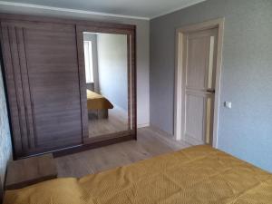 a bedroom with a large mirror and a bed at Kandavas Street City Center Apartment in Daugavpils