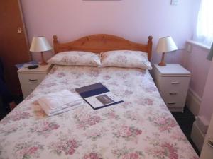 a bedroom with a bed with a book on it at The Sandhill in Sandown