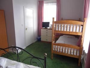a bedroom with a bunk bed and a desk at The Sandhill in Sandown