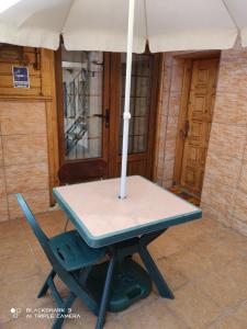 een picknicktafel met een parasol en een stoel bij Garsoniera Mikha in Sinaia