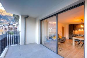 a living room with a view of a balcony at Appartement 60M2 - TELECABINE SAINT GERVAIS - 201 in Saint-Gervais-les-Bains