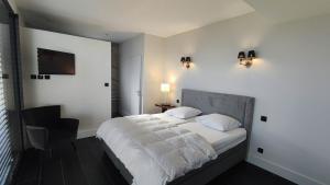 Un dormitorio con una cama con sábanas blancas y una silla. en Villa Gabiano, en Rayol-Canadel-sur-Mer 19 fotos más