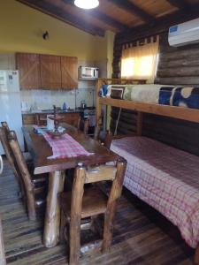 a dining room with a table and a bunk bed at Cabañas y Bungalow " La Comarca" in Concepción del Uruguay