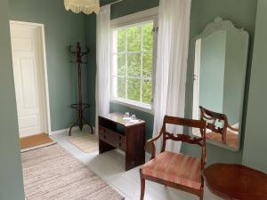 a room with a table and a mirror and a chair at Vinter Bed & Breakfast in Sauvo