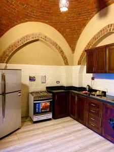 a kitchen with a refrigerator and a stove top oven at Gold's Villa in Luxor