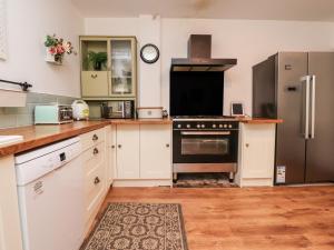 a kitchen with white cabinets and a black oven at 112 Balmoral Road in Morecambe
