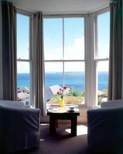 una sala de estar con vistas al océano desde una ventana en organic panda en St Ives