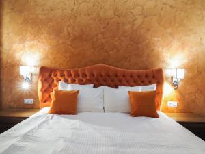 a bedroom with a large bed with orange pillows at Boutique Central in Sibiu