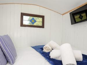 a bedroom with a bed with a window and towels at Shepherds Hut in Lostwithiel