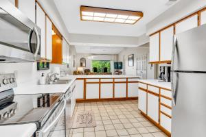 uma cozinha com balcões brancos e um frigorífico em Suite Spot at the Foothills condo em Branson