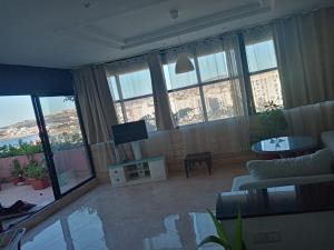 a living room with a couch and a tv at Appartement bord de mer et piscine en option in Tangier