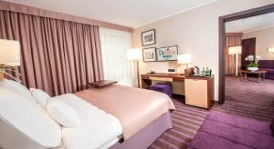 a hotel room with a bed and a desk at Hotel DeSilva Premium Opole in Opole +49 photos