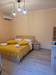 a bedroom with a large bed with yellow pillows at Kleanthi and Kostas Studios in Symi