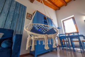 a blue hutch with a hanging chair in a room at Happy Guest Apartments - Blue Lake Therapy in Riva di Solto
