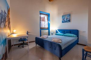 a bedroom with a blue bed and a desk at Happy Guest Apartments - Blue Lake Therapy in Riva di Solto