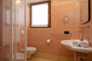 a bathroom with a toilet and a sink and a window at Hotel Sciatori in Livigno +33 photos