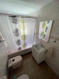 ein Badezimmer mit einem WC, einem Waschbecken und einem Duschvorhang in der Unterkunft Encantadora Habitación Privada cerca del mar in Málaga