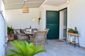 a patio with a table and chairs and a green door at Apartman Paula in Milna