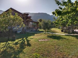 a house with a grassy yard next to a house at Detached stone house with access to a large garden near beach in Kemer