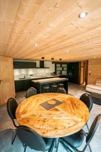 CHALET LES CERFS في شاتيل: طاولة وكراسي خشبية في مطبخ