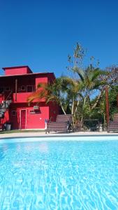 ブジオスにあるPousada Arpoador de Búziosの赤い家の前のスイミングプール