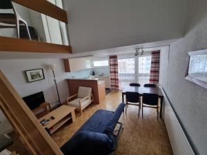 ein Wohnzimmer mit einem blauen Sofa und einem Tisch in der Unterkunft Fortuna 307 in Leukerbad
