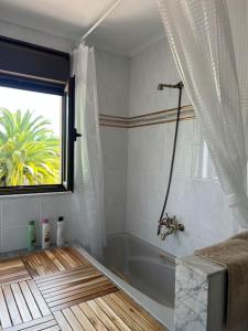 baño con bañera y ventana en La Casona de la Carbayeda en Oviedo