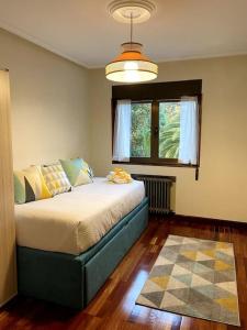 1 dormitorio con 1 cama en una habitación con ventana en La Casona de la Carbayeda, en Oviedo