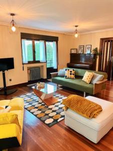 ein Wohnzimmer mit einer Couch und einem Klavier in der Unterkunft La Casona de la Carbayeda in Oviedo + 47 Fotos