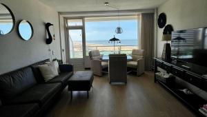 a living room with a couch and a table with a view at Apartment Pascalle in Zandvoort
