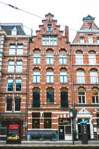 ein großes rotes Backsteingebäude in einer Stadtstraße in der Unterkunft Hotel La Bohème in Amsterdam