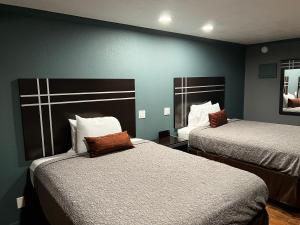 two beds in a room with blue walls at Relax Inn Ashdown in Ashdown