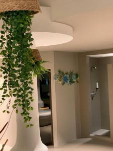 a large white vase with a plant in a room at Hotel Saalbacher Hof in Saalbach-Hinterglemm
