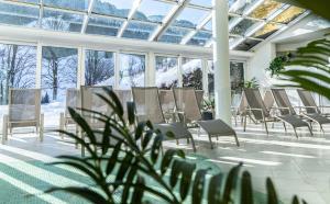 a room with a bunch of chairs and a plant at Hotel Saalbacher Hof in Saalbach-Hinterglemm