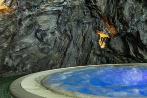 a bath tub filled with blue water in a cave at Hotel Saalbacher Hof in Saalbach-Hinterglemm