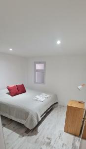a white room with a bed with red pillows on it at Puerto La Casa in San Martín de los Andes +62 photos