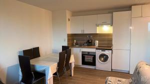 a kitchen with a table and a washing machine at Appartement Futuroscope-E' in Chasseneuil-du-Poitou
