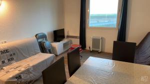 a room with a table and chairs and a television at Appartement Futuroscope-E' in Chasseneuil-du-Poitou
