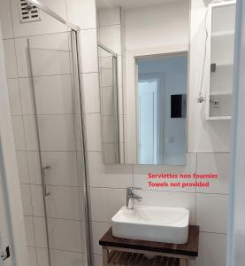 ein Badezimmer mit Waschbecken und Spiegel in der Unterkunft Appartement 2 chambres 200m plage Nieuwpoort Bad in Nieuwpoort