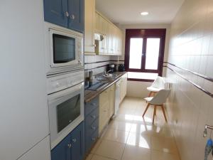 a kitchen with blue cabinets and a white appliances at Seaside in Gran Tarajal