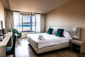 a hotel room with a bed and a large window at Estalagem Muchaxo Hotel in Cascais