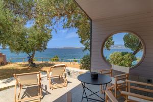 een patio met stoelen en een tafel en uitzicht op het water bij Via Lassi Kefalonia in Argostoli