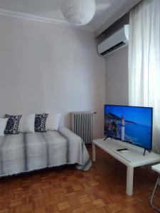 a bedroom with a bed and a television on a table at Emme Central - spacious apartment in Kavala
